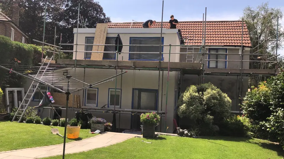 Render work in progress on a detached house under scaffolding
