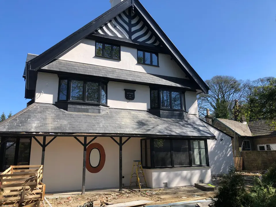Large new-build home with a white render finish and dark roof
