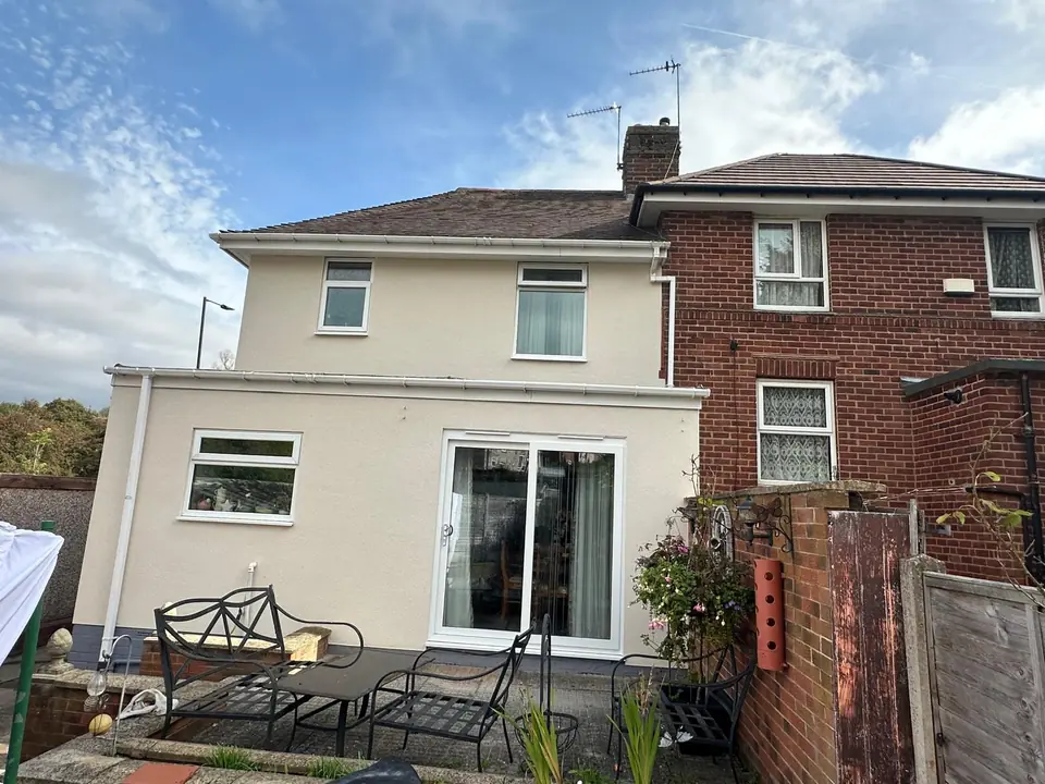 Semi-detached house after the pebbledash was replaced with a smooth cream render