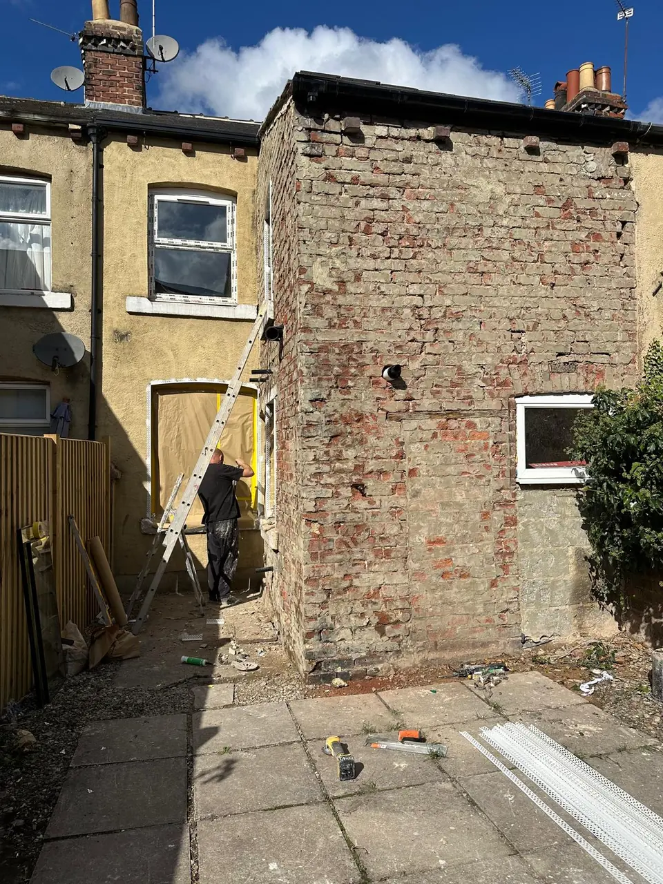 Rear of a brick terrace before rendering, with weathered brickwork